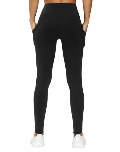 Back view of person wearing black leggings and white shoes.