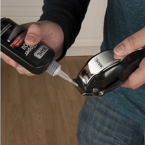 Person applying oil to hair clipper blades