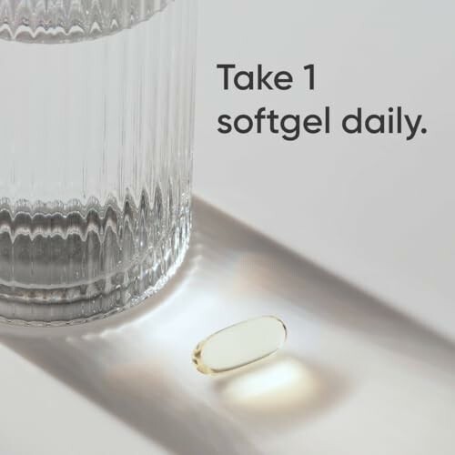 Glass of water with a softgel capsule beside it.