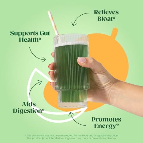 Hand holding a glass of green juice with health benefit claims.