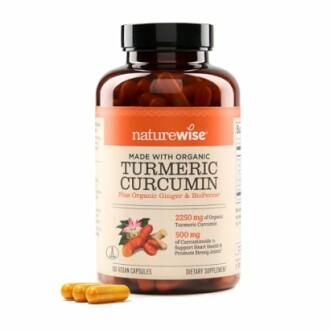 Bottle of NatureWise organic turmeric curcumin capsules with pills beside it.