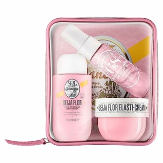 Pink skincare set with lotion, cream, and spray in a pink case.