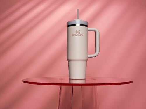 Stanley tumbler on a pink table with pink background