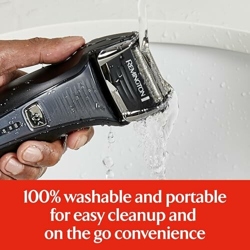 Hand rinsing an electric shaver under water.
