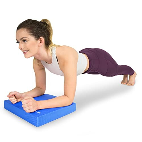 Woman performing a plank on a blue exercise pad.