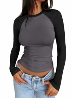 Woman in black and gray long-sleeve top with jeans.